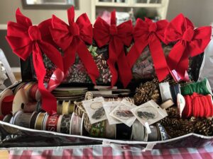 Christmas in August Basket #12 -wrapping caring case, gold pinecone wreath, rolls of wrapping paper, giant red bows, spools of ribbon, assorted bows, hockey ornaments, and much more!